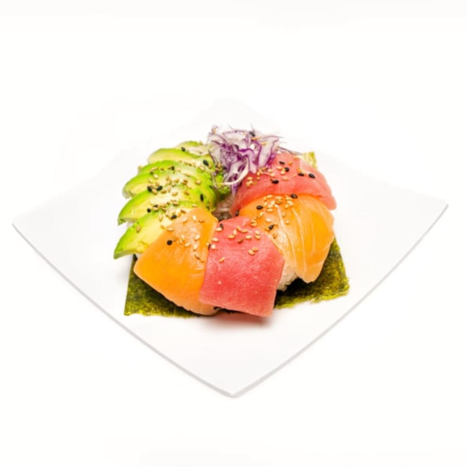Twin Sushi PDX rainbow roll with tuna, salmon, avocado, and sesame seeds on a white plate.